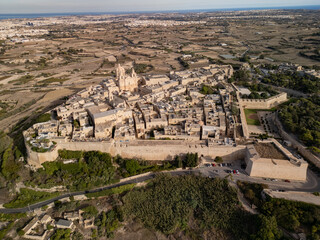 Fototapeta premium Epic aerial panorama of the silent city Mdina on a hilltop at sunset, medieval fortified city and ancient architecture, Malta, 4K drone