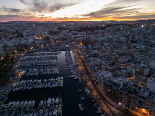 Rows of yachts in the strait in Malta at night - drone aerial view