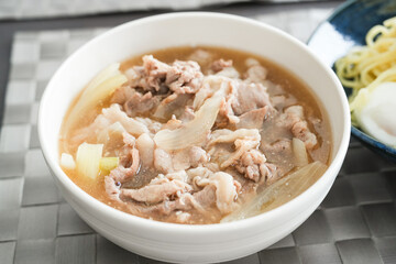 豚肉と玉ねぎの煮込みを器に盛り付けた料理