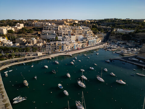 Horizontal aerial panorama of luxury yachts at the Grand Harbour Marina. View towards Birgu and Fort St. Angelo in Valletta, Malta.