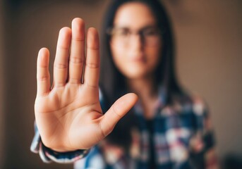 Determined woman holding hand up in stop gesture, conveying firm boundaries and personal safety