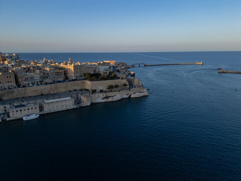 Malta Valletta Grand Harbour entrance with historic Fort St Elmo and breakwater aerial drone view.
