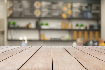 Wooden table top and blurred background in coffee shop and restaurant walls of the shop, Mock up for display of product.
