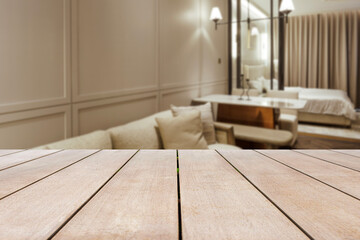 Wood table in front of blurred beautiful bedroom looks clean and decorated in comfortable tones, suitable for relaxation. Can be used for display or montage for show your products.