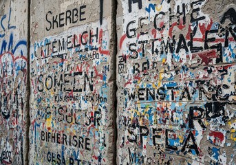 Obraz premium Historic berlin wall section covered in layers of colorful graffiti and decay.
