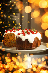 Tasty Christmas cake with red currants on table. Bokeh lights