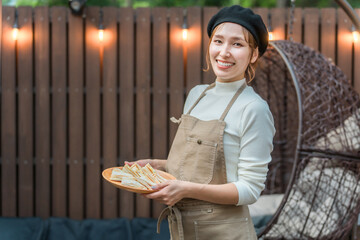 A young Asian woman wearing an apron working in a stylish cafe