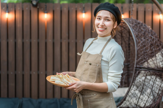 A young Asian woman wearing an apron working in a stylish cafe
