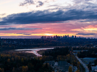 Fototapeta premium Sunset Over Burnaby Skyline at Dusk with River and Forest in Greater Vancouver