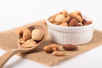 Mixed nuts consisting of almonds, cashews and peanuts, roasted with salt. Healthy snack on white background.