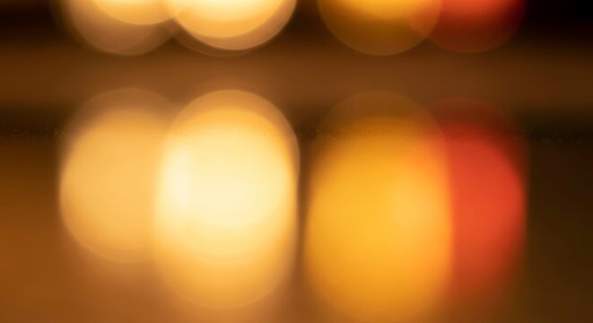 Soft focus bokeh lights in warm golden and orange tones, abstract background