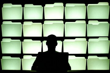 Digital Dossier: A shadowy figure surveys rows of luminous file folders, their glow creating an atmosphere of intrigue and mystery, hinting at hidden information and surveillance.