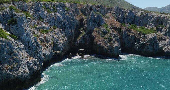 Spiaggia di Cala Domestica Secluded Cove On The Southwestern Coast Of Sardinia Near Buggerru In Italy. Aerial Pullback Shot