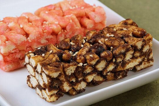 Two mixed flavor sachima bars arranged on a clean plate, highlighting texture and colors of this traditional sweet snack.