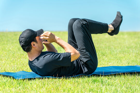 Middle-aged man doing strength training and abdominal exercises in the park
 - Powered by Adobe