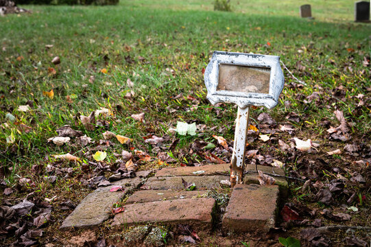 Bricks and a small, empty, old plaque marking a grave site in Old City Cemetery, Lynchburg Virginia