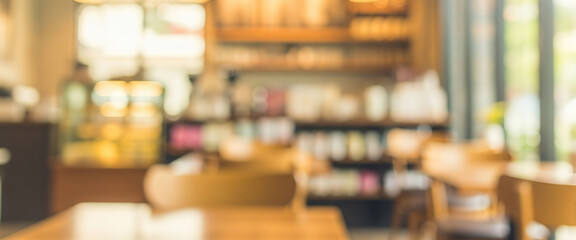Blurred cafe interior with warm lighting, wooden textures, and soft focus. Modern seating area and decorative elements, suitable for lifestyle and creative backgrounds.
