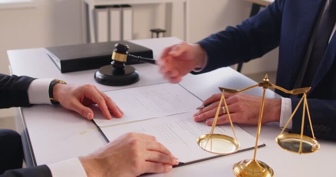 Client exchanges a handshake with a male lawyer thanking him for providing professional legal advice, finding a solution and helping resolve a dispute. Law, justice, and legal services concept