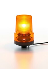 An amber industrial beacon light is illuminated on a pristine white surface casting a warm glow A power cord extends from its dark base