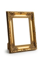 An antique-style ornate gold picture frame with detailed carvings stands upright on a white surface presenting a blank white interior