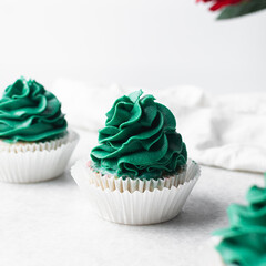green frosting on cupcakes with a white background, cupcakes in white liners with tall buttercream swirl, green buttercream frosted cupcakes on a white background