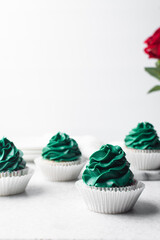 green frosting on cupcakes with a white background, cupcakes in white liners with tall buttercream swirl, green buttercream frosted cupcakes on a white background