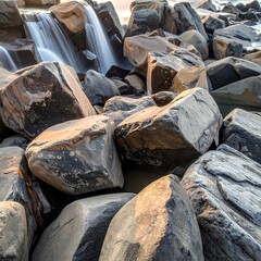 Close-up of cascading water flowing past large, weathered rocks