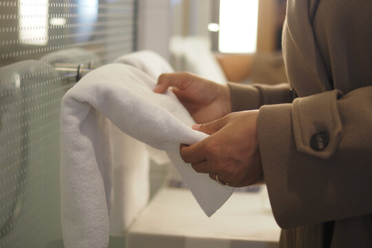 Person drying hands with a towel in a modern bathroom
