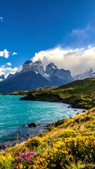 Obraz premium Stunning vista with azure lake, mountains, and wildflowers under blue sky