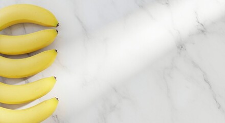 A close up of several yellow bananas arranged on a white marble surface with natural light shining through