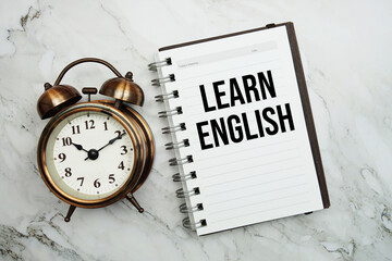 Learn English text written on notepad with alarm clock