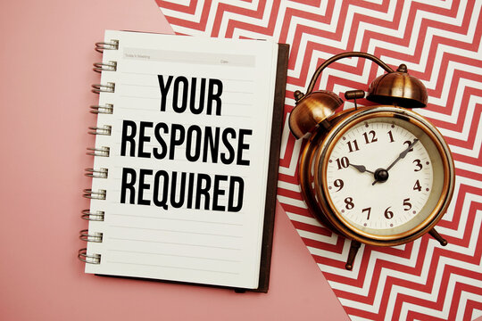 Your Response Required text written on notepad with alarm clock