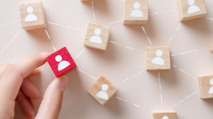 Strategic Networking: A hand carefully places a vibrant red cube among other neutral cubes connected by fine lines, symbolizing strategic networking and individual contribution within a larger system.