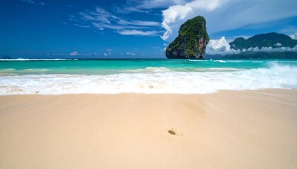 Idyllic tropical beach with turquoise water and rock formation.