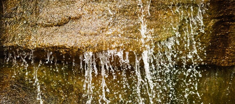 Water cascading over textured rock face in a natural, flowing display