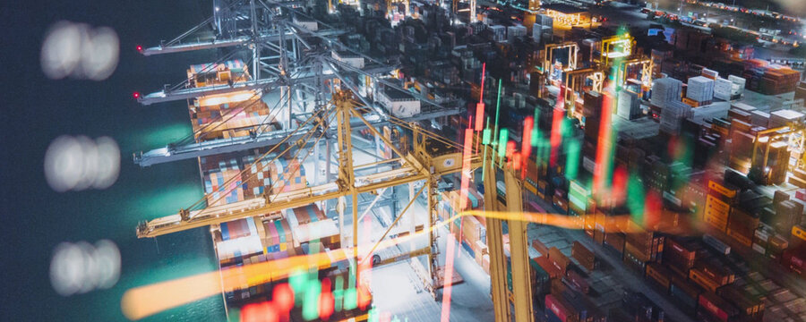 Nighttime view of a busy shipping port with financial market data overlay - Powered by Adobe