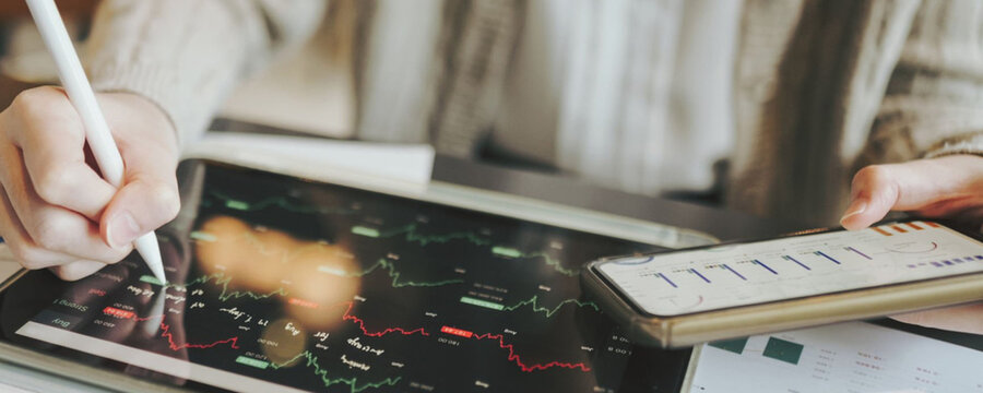 Analyzing financial data on a tablet and smartphone for investment decisions