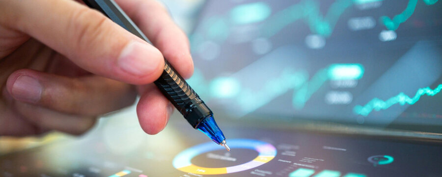 Analyzing financial data on a tablet with a stylus, close-up view