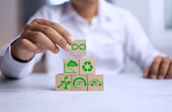 CO2 emission reduction concept with a man in white arrange wooden cube for environment sustainable development, recycle or electric vehicle represent to zero within 2050 - Powered by Adobe