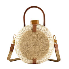 Circular woven purse with leather straps on a black background