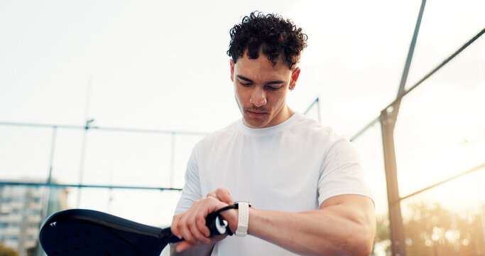 Man, smart watch and padel for fitness, click and check training stats with results for cardio. Person, athlete and iot wristwatch for timer, racket or application in city at tennis court for game - Powered by Adobe