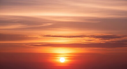 Stunning orange sunset with radiant sun and soft clouds offers a peaceful, inspiring vista perfect for travel, nature, or serene backgrounds and graphics.