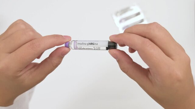 Physician showing an insulin glargine vial before injection on a white background