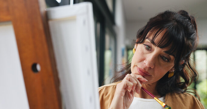 House, painter and woman with canvas, thinking and hobby with deadline, creativity and brush. Artist, contemplation and mature person with ideas, tools and design process for project and inspiration