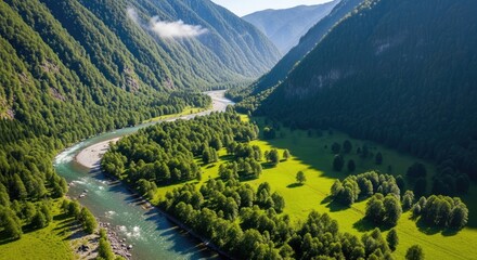 Aerial view of a river flowing through a lush green mountain valley
