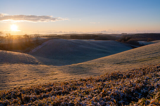Golden sunrise over frosty early morning hills
