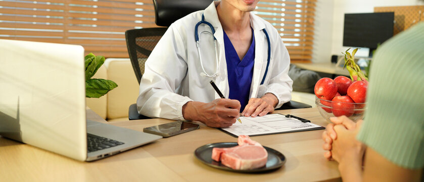 Dietician, male nutrition specialist consulting woman, developing healthy diet, dietary program. Dietary consultant asking, giving male patient advice, help, nutritional information, new meal plan