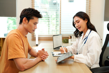 Obraz premium Female doctor explaining diagnosis to her patient during a medical consultation in a bright medical office, healthcare and medical concept. Medicine and health care concept