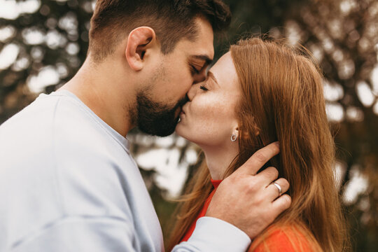romantic couple sharing tender kiss, couple exchanging heartfelt kiss amidst serene natural surroundings
