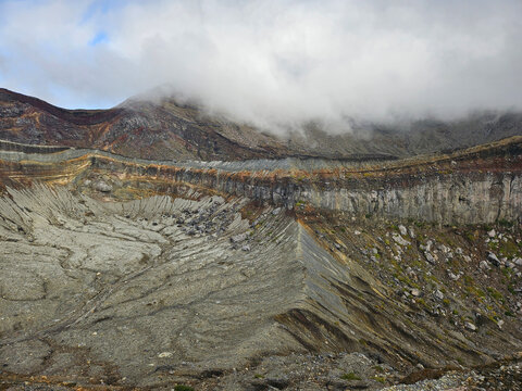 Unique landscape of the crater of Nakadake in Mount Aso Japan with rock and mountain background